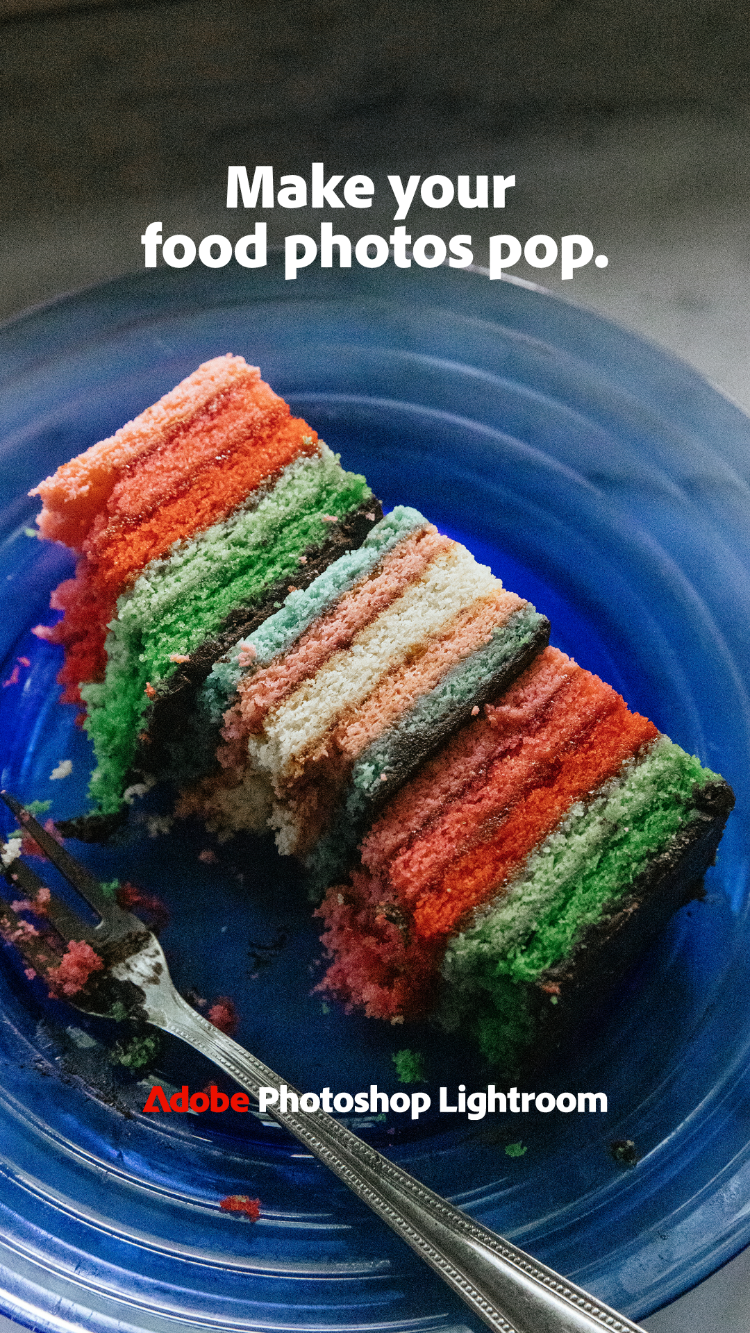 Colorful layered cake on a blue plate with a fork, partially eaten.