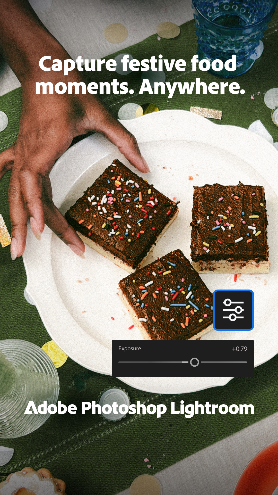 Plate with three chocolate birthday cake squares topped with colorful sprinkles on a green tablecloth decorated with confetti and next to a blue drinking glass.